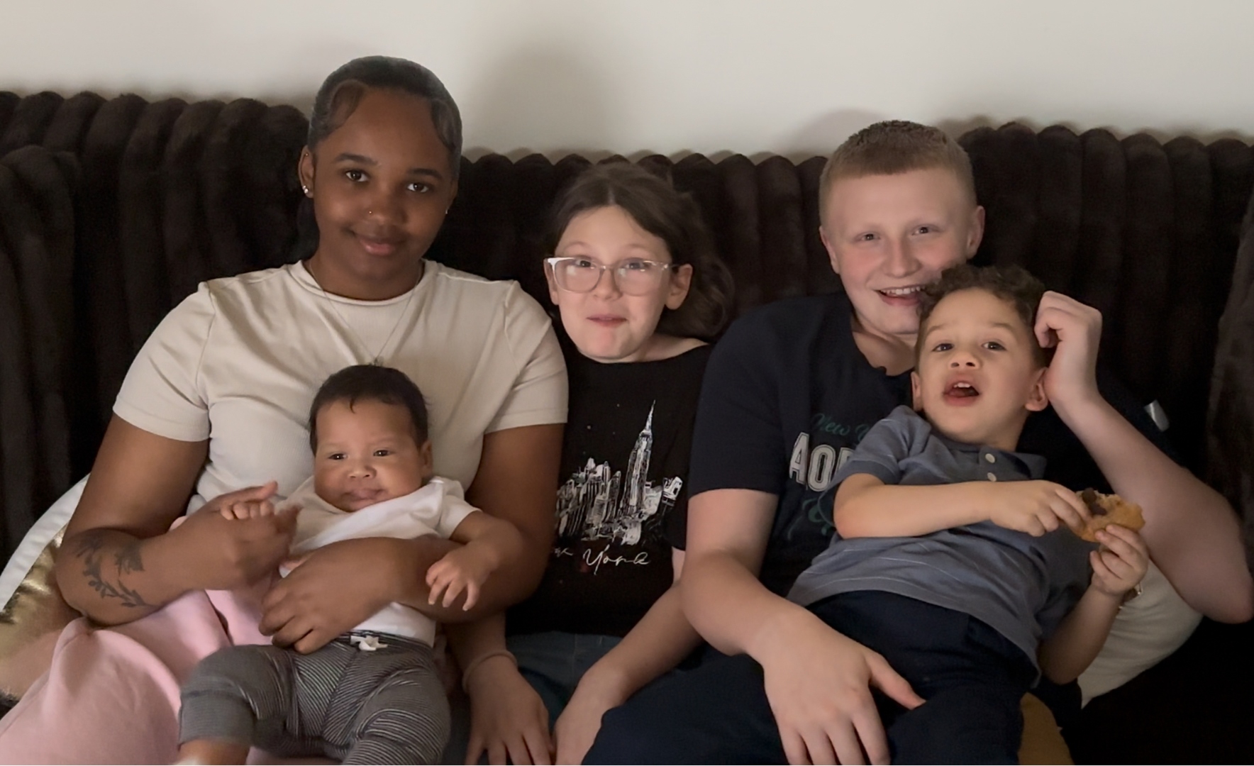 Anthony's five children together on a couch, smiling.